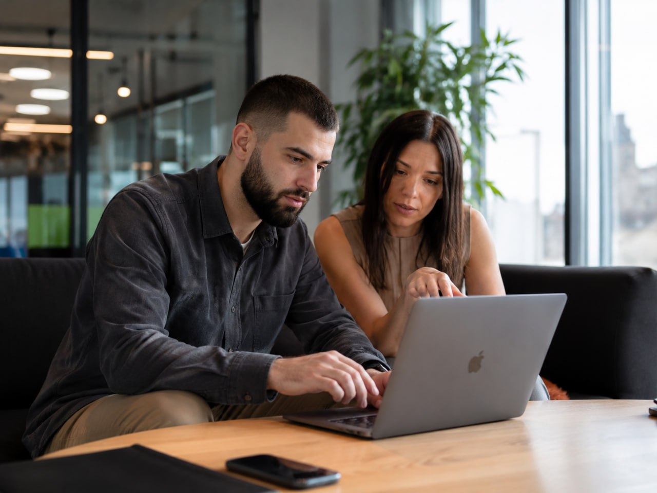 Two specialists reviewing work on a laptop